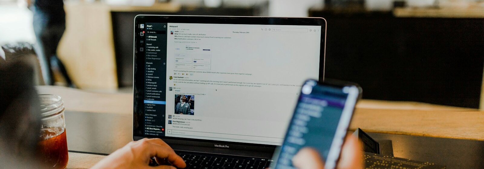 person using phone and laptop