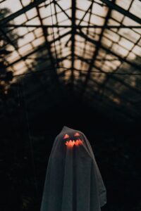 white sheet thrown over an illuminated pumpkin to make a ghost decoration for halloween