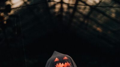 white sheet thrown over an illuminated pumpkin to make a ghost decoration for halloween