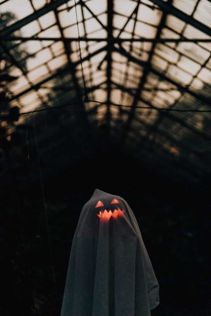 white sheet thrown over an illuminated pumpkin to make a ghost decoration for halloween