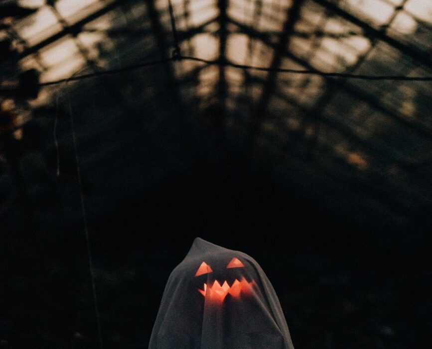 white sheet thrown over an illuminated pumpkin to make a ghost decoration for halloween
